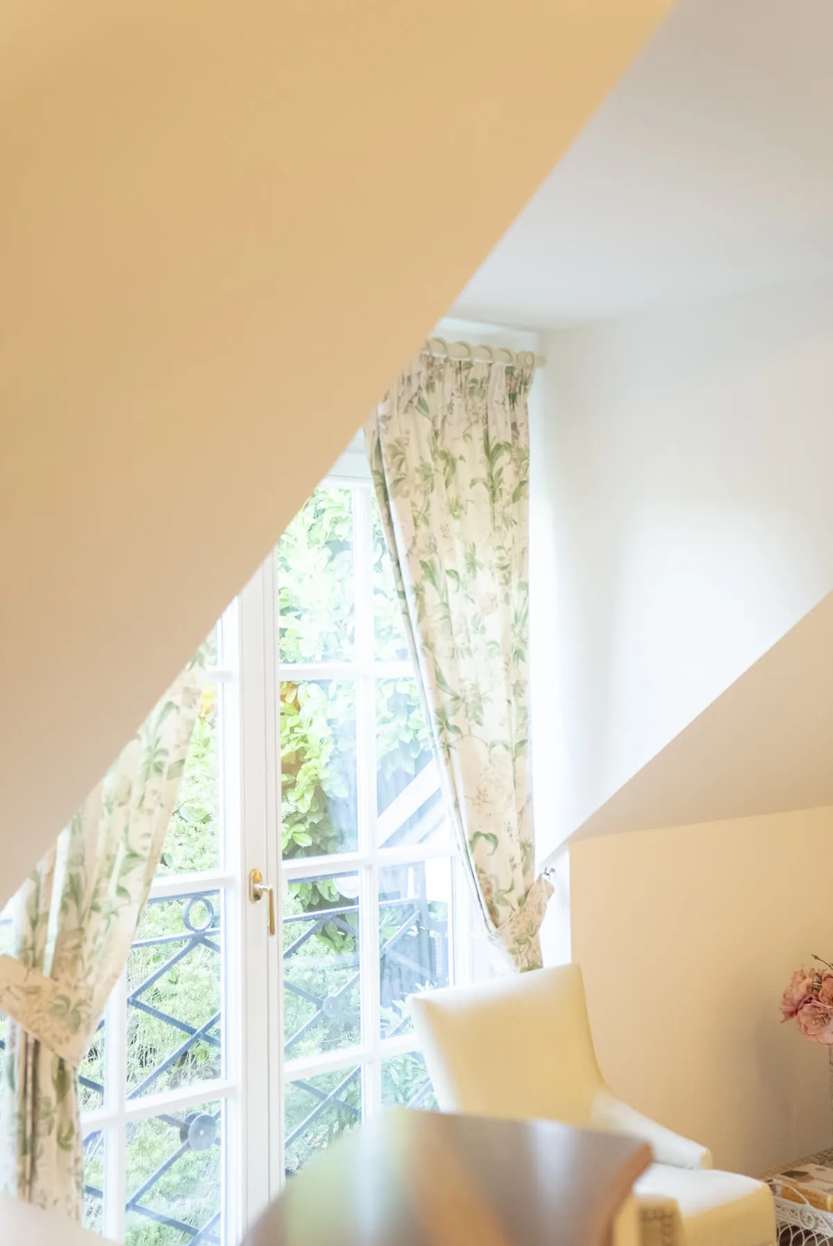 Fenster mit Blumenvorhängen und Blick in den Garten der Ordination